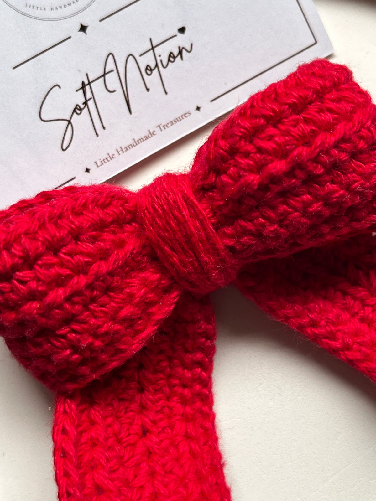 Macro close-up of red crochet bow texture and centre knot