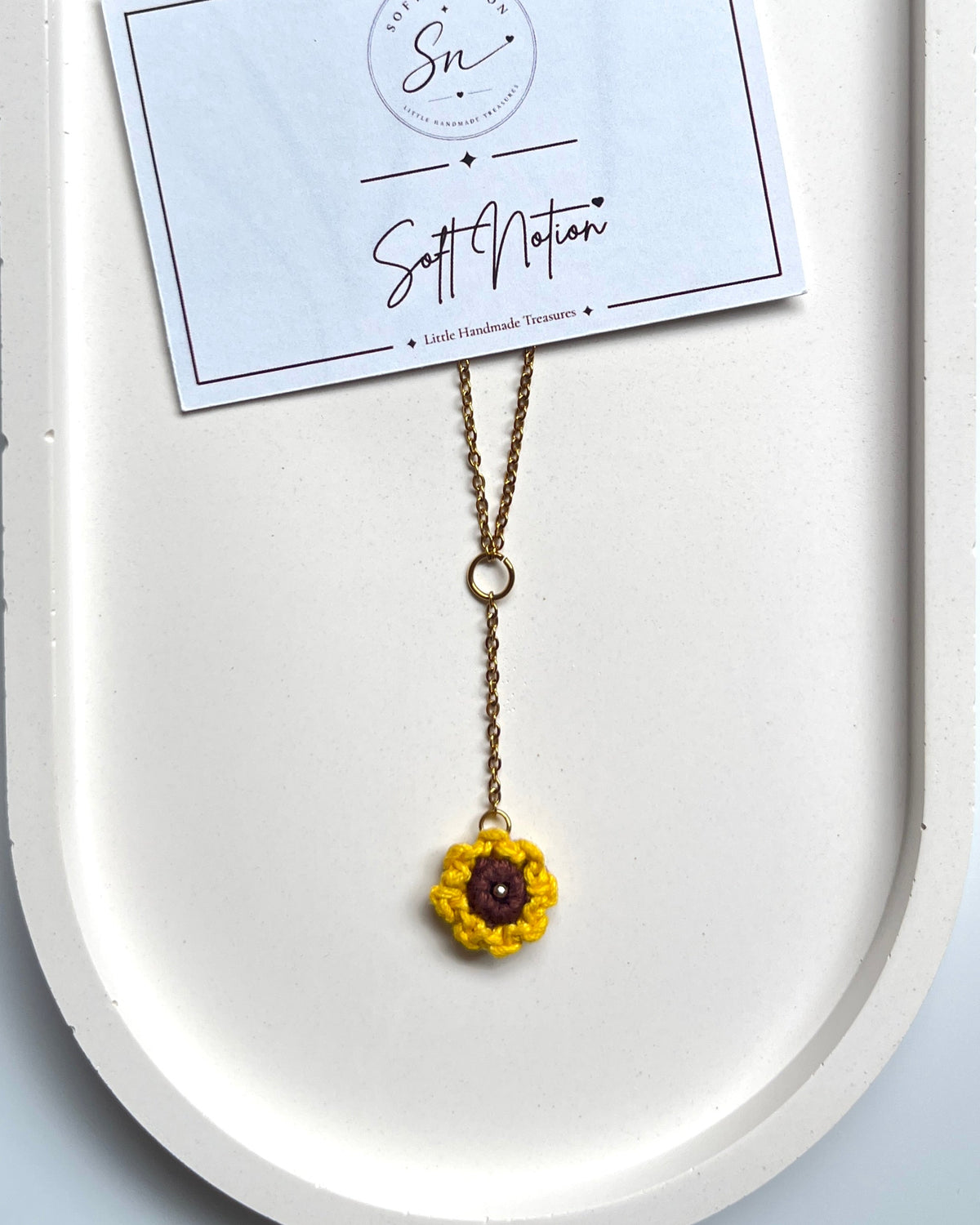 Sunshine Necklace with yellow crochet sunflower charm displayed on a gold-toned chain