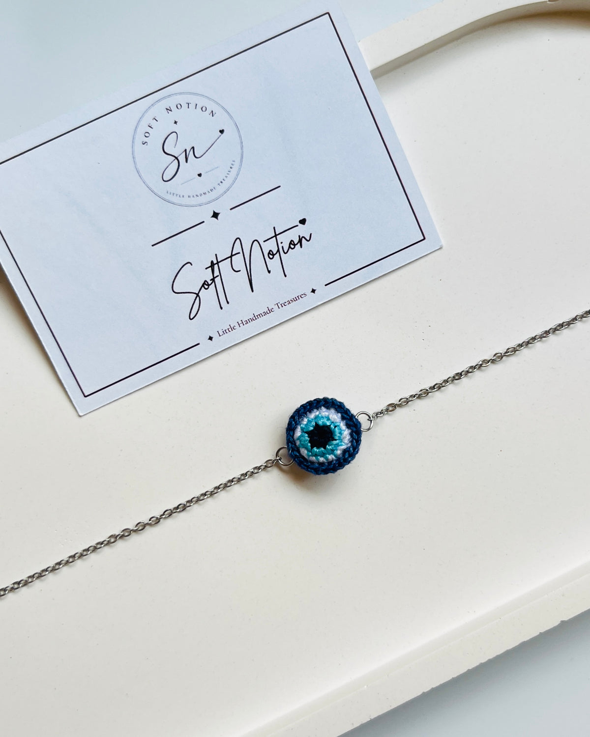 Handmade crochet evil eye bracelet with blue miniature 3D charm and silver-toned chain