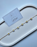 Daydream Bracelet with hand-crocheted white and yellow daisies on a gold-toned chain