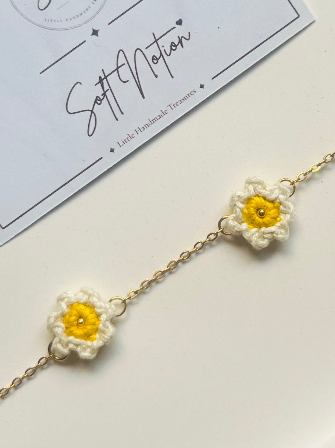 Close-up of hand-crocheted daisy charms on Daydream Anklet